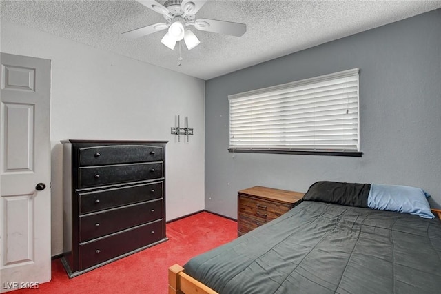 bedroom with ceiling fan, carpet floors, and a textured ceiling