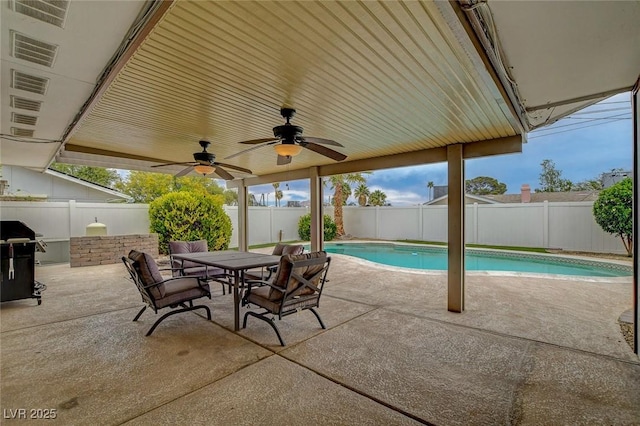 view of patio / terrace featuring a fenced in pool, outdoor dining area, a fenced backyard, and a ceiling fan