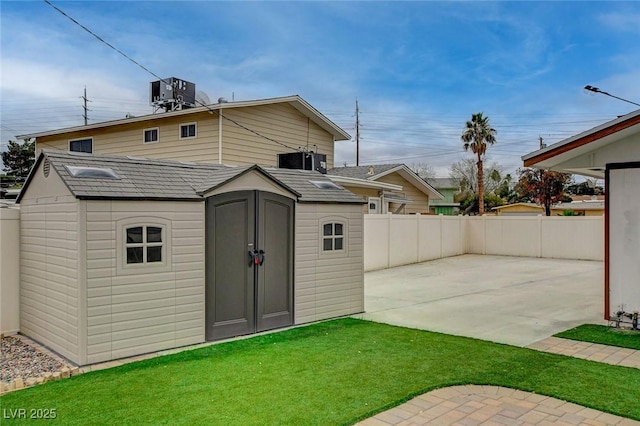 view of shed with central air condition unit and fence