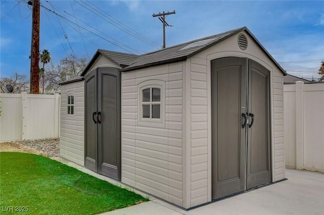 view of shed featuring fence