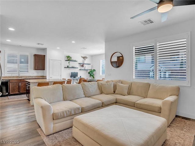 living area with light wood-style flooring, recessed lighting, visible vents, and ceiling fan