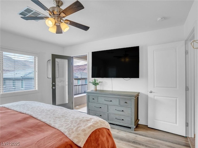 bedroom with access to exterior, light wood-style flooring, a ceiling fan, and visible vents