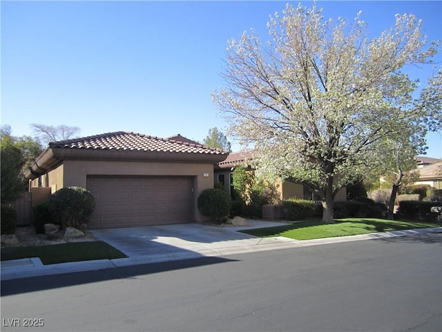 mediterranean / spanish home featuring stucco siding, a garage, driveway, and a tiled roof