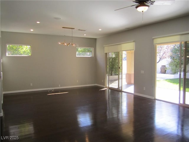 empty room with dark wood-style floors, recessed lighting, a healthy amount of sunlight, and baseboards