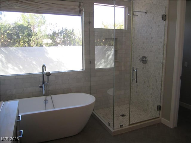 bathroom featuring a freestanding bath and a shower stall