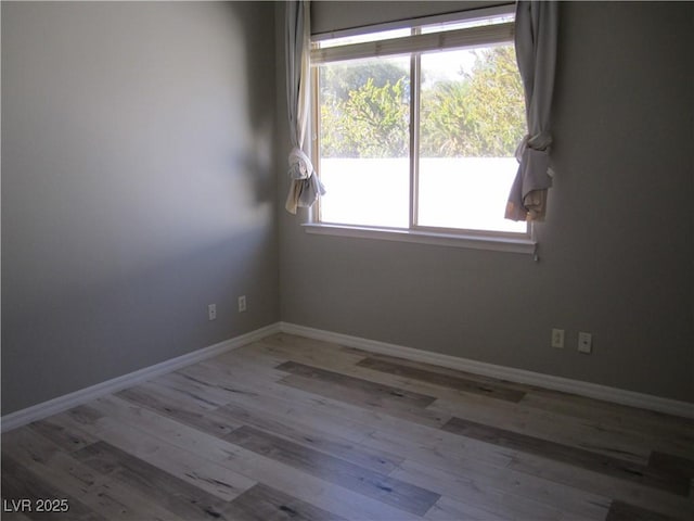 unfurnished room with baseboards and wood finished floors