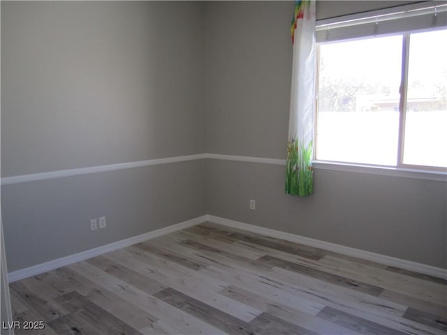 empty room featuring baseboards and wood finished floors