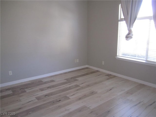 empty room with light wood-style flooring and baseboards