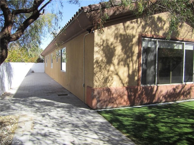 view of home's exterior with a lawn and stucco siding