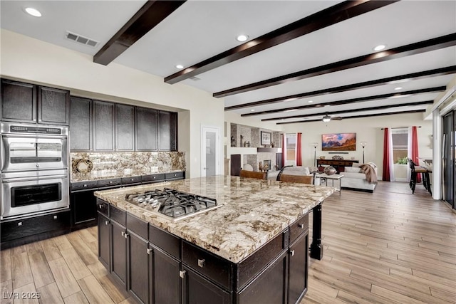 kitchen with light wood finished floors, visible vents, appliances with stainless steel finishes, and decorative backsplash