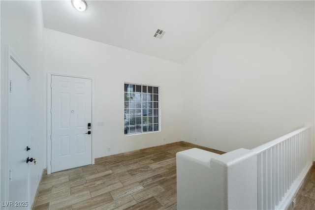 foyer with a high ceiling, wood finished floors, and visible vents