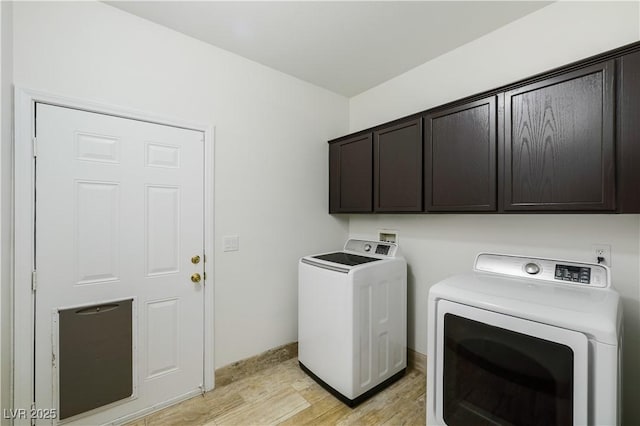 laundry area with cabinet space, separate washer and dryer, and light wood-style flooring