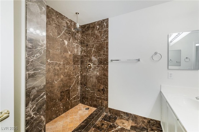 bathroom with tiled shower and vanity