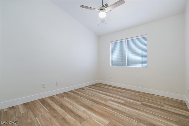 spare room featuring vaulted ceiling, baseboards, light wood-type flooring, and ceiling fan