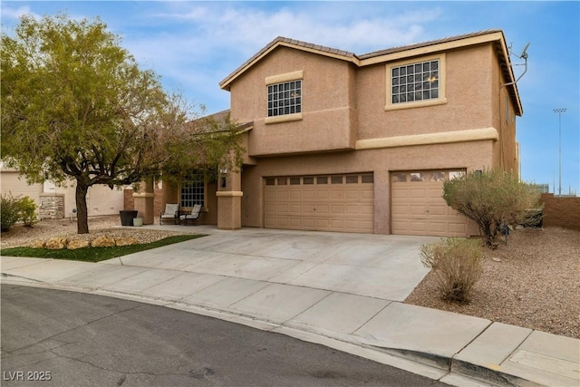 traditional-style house with stucco siding, a garage, and concrete driveway