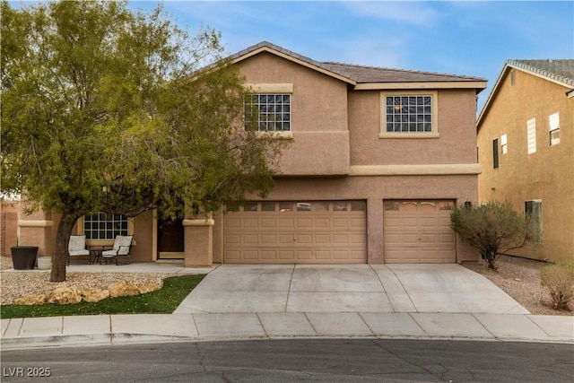 view of front of home with concrete driveway, an attached garage, and stucco siding