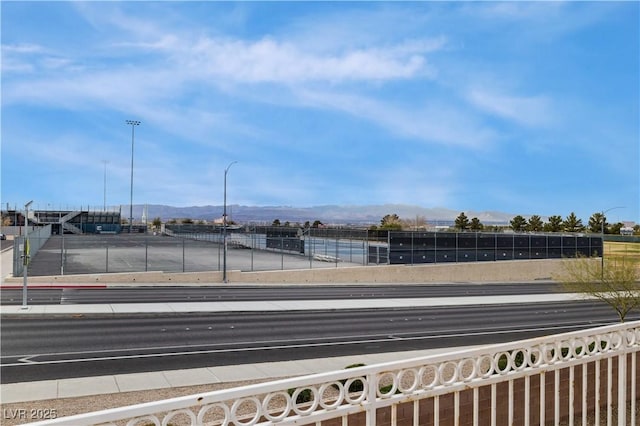 exterior space featuring sidewalks, a mountain view, and street lights