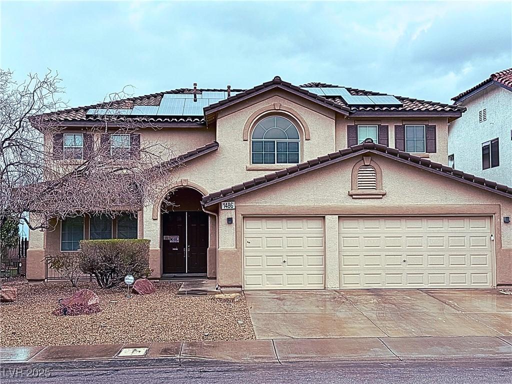 view of front of home with stucco siding, a tiled roof, and concrete driveway