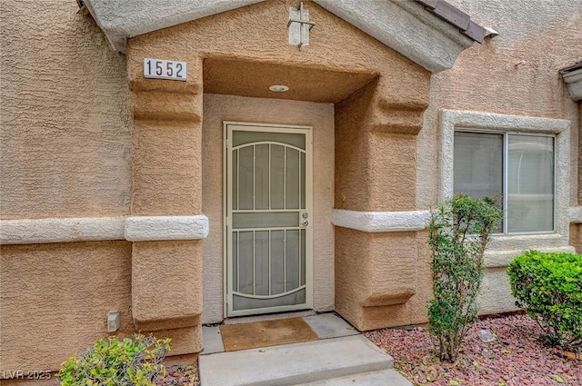 view of exterior entry featuring stucco siding