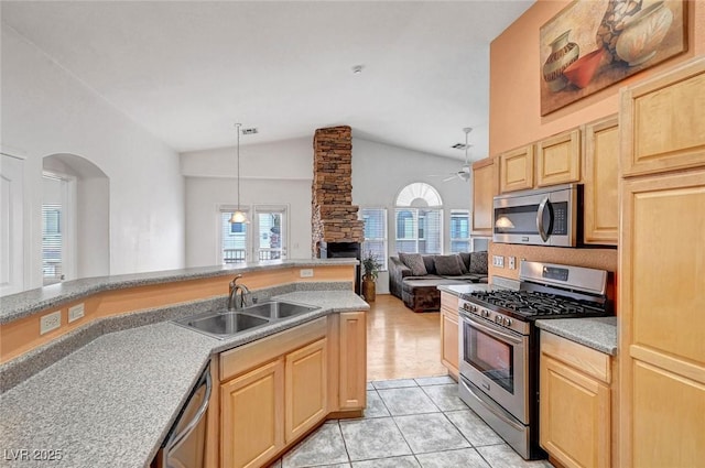 kitchen with light tile patterned floors, light brown cabinets, a sink, stainless steel appliances, and light countertops