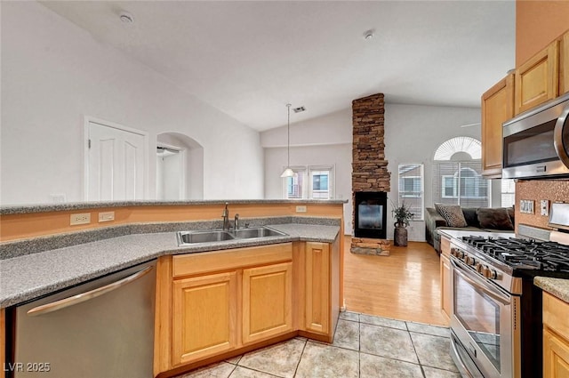 kitchen featuring a sink, stainless steel appliances, a wealth of natural light, and light tile patterned floors