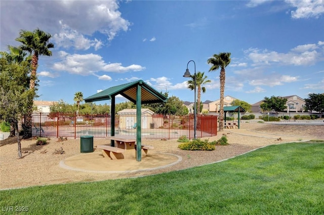 community jungle gym featuring a yard and fence