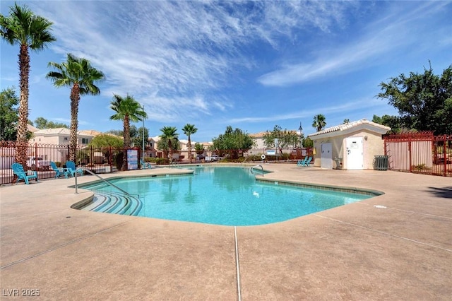 pool with a patio area and fence