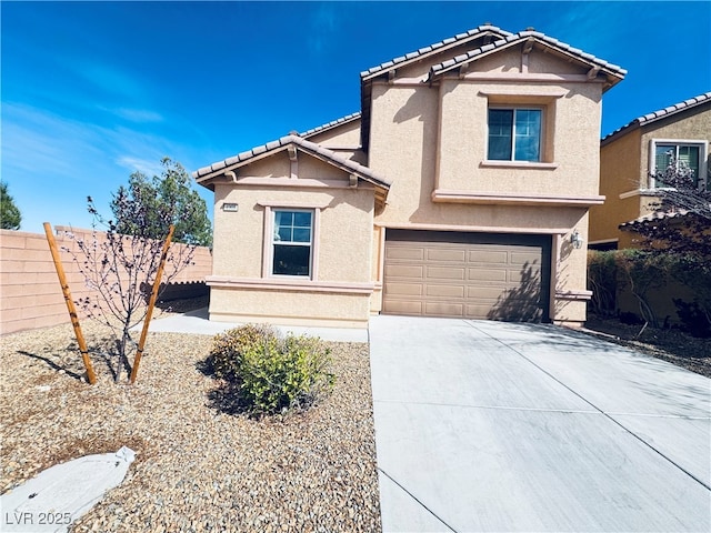 traditional-style home with fence, a tile roof, concrete driveway, stucco siding, and an attached garage