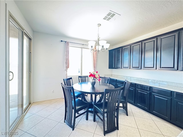 dining room with a notable chandelier, light tile patterned floors, and visible vents