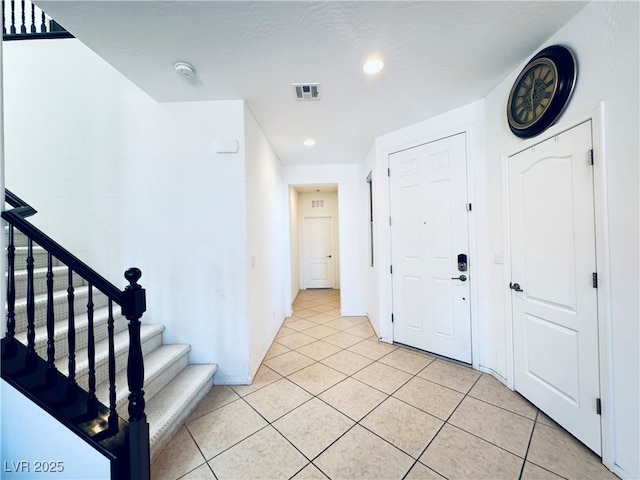 entrance foyer with recessed lighting, visible vents, light tile patterned flooring, and stairs