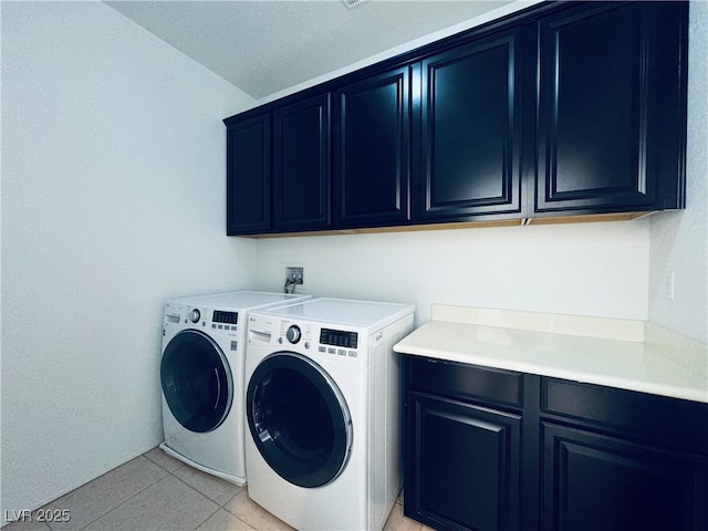 laundry area with washing machine and dryer, light tile patterned floors, and cabinet space