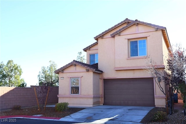 traditional-style house with stucco siding, fence, concrete driveway, a garage, and a tiled roof