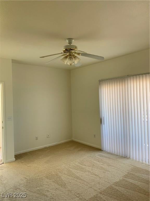 carpeted empty room featuring baseboards and a ceiling fan