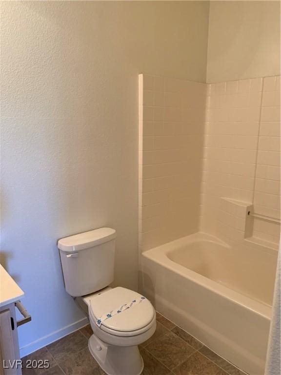 bathroom featuring vanity, washtub / shower combination, baseboards, tile patterned flooring, and toilet