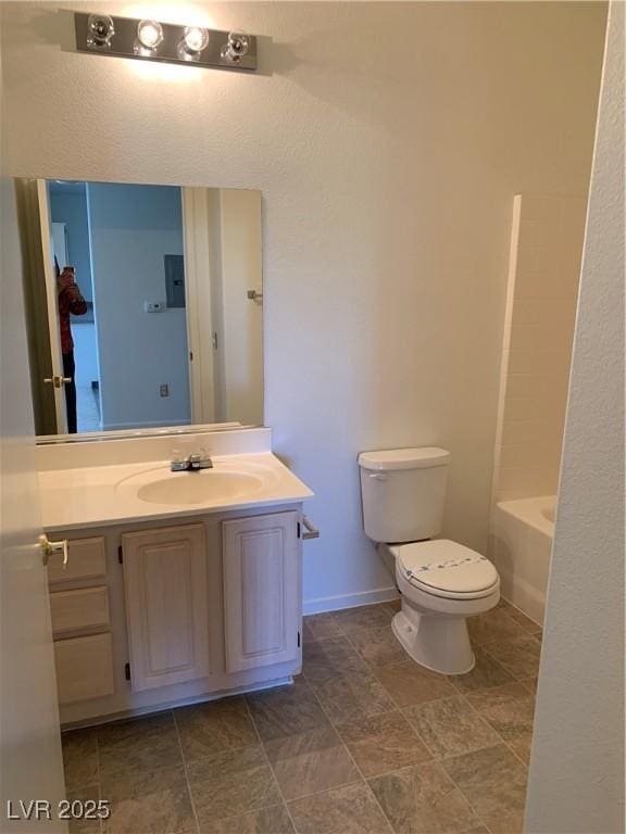 bathroom featuring vanity, baseboards, a tub, walk in shower, and toilet