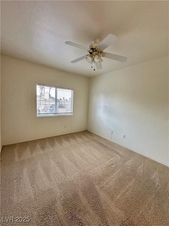 carpeted spare room with a textured ceiling and ceiling fan