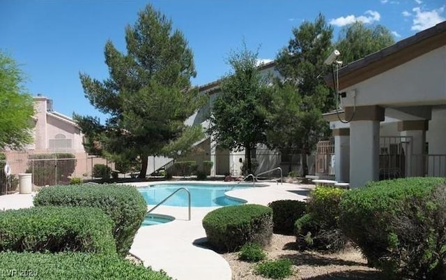 community pool featuring a patio and fence