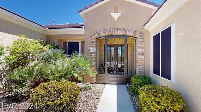 view of exterior entry featuring french doors and stucco siding