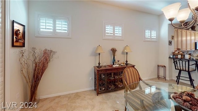 sitting room featuring a notable chandelier, a healthy amount of sunlight, and baseboards