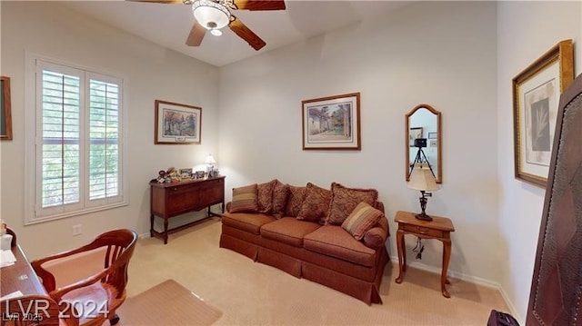 living room with a ceiling fan, a wealth of natural light, and light carpet