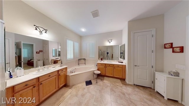 full bath with a garden tub, two vanities, visible vents, and a sink