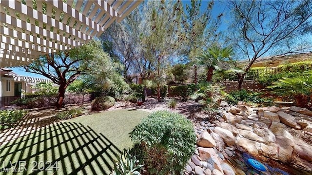 view of yard with a pergola and fence