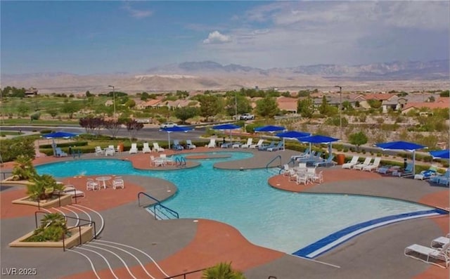 view of swimming pool with a patio area and a mountain view