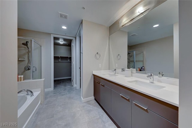 bathroom with a sink, visible vents, a spacious closet, and a shower stall