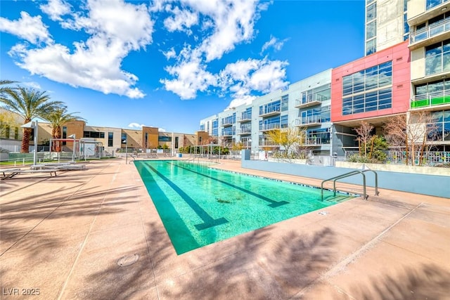 community pool featuring a patio and fence