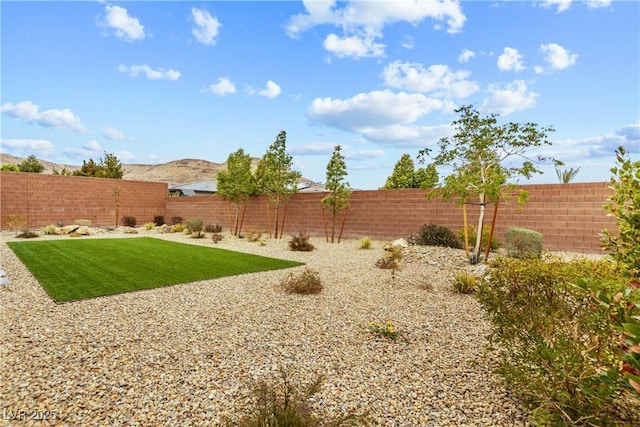 view of yard with a mountain view and a fenced backyard