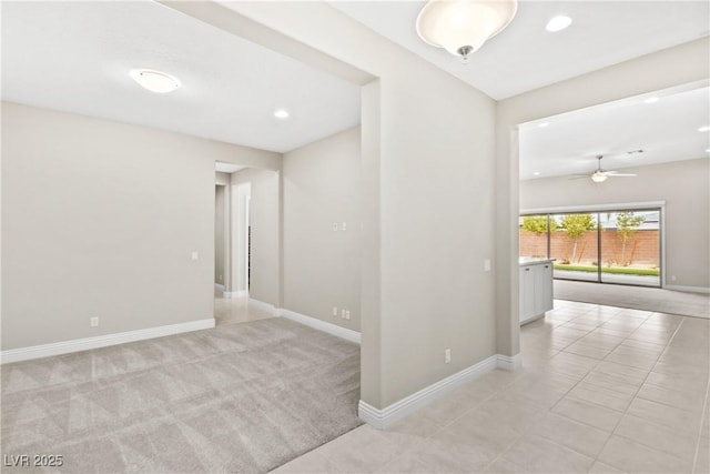 spare room with baseboards, light tile patterned flooring, recessed lighting, ceiling fan, and light colored carpet