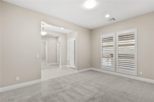 unfurnished room with visible vents, baseboards, and carpet