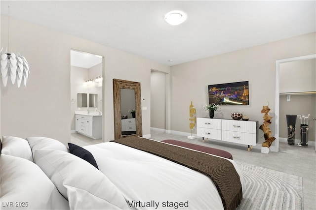 bedroom with a closet, light colored carpet, ensuite bathroom, and baseboards