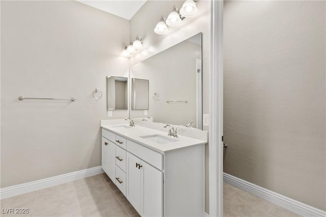 full bathroom with tile patterned flooring, double vanity, baseboards, and a sink